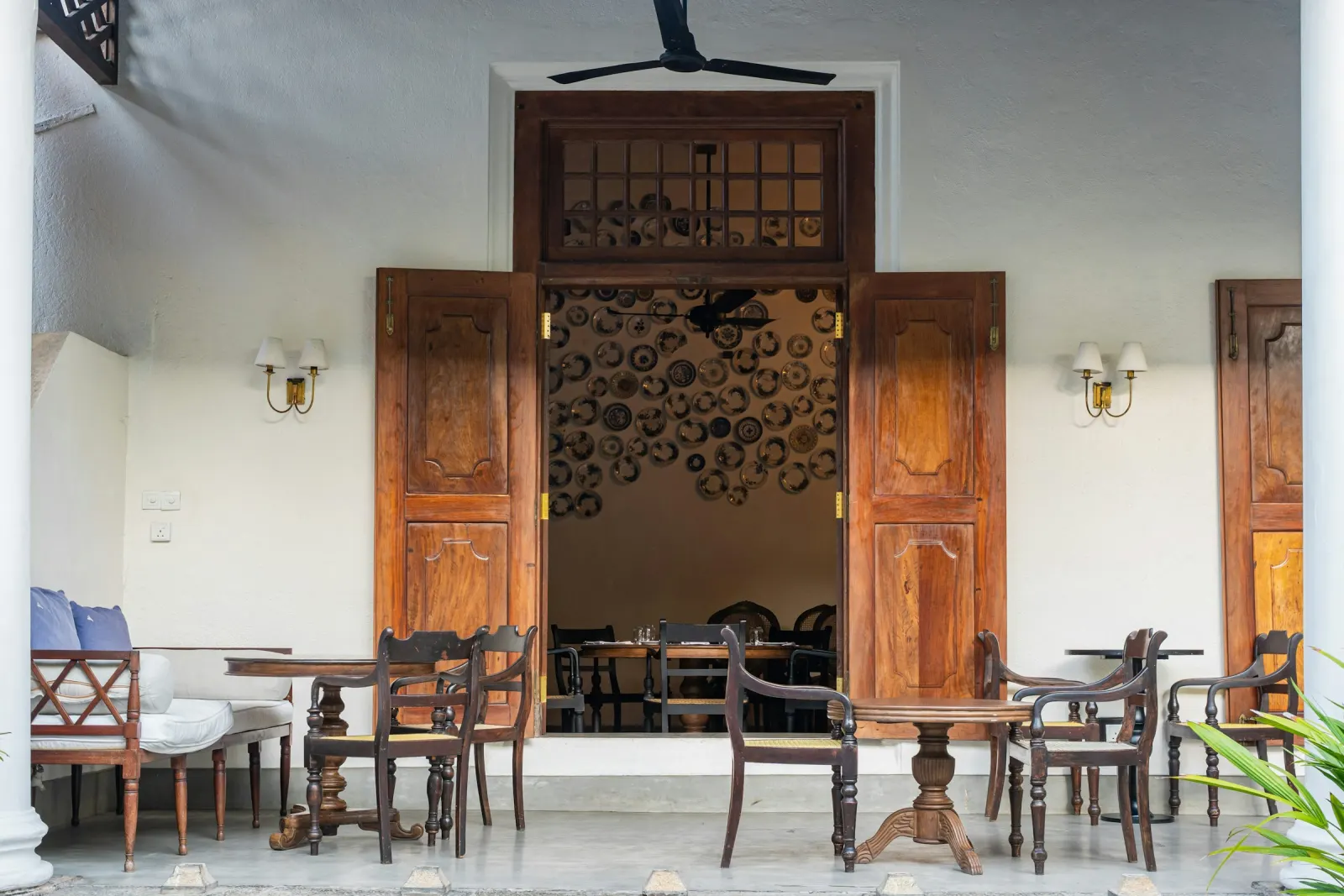Galería de una casa caribeña con puertas de madera abiertas